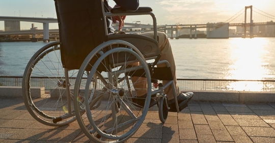 Man on a wheelchair looking at sunset